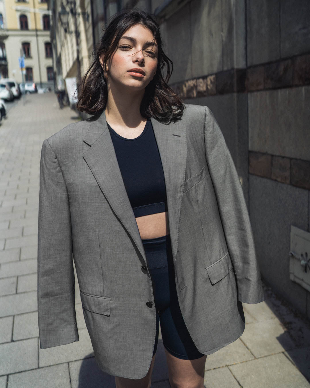 Woman in a grey blazer over her shoulders in a Stockholm street 