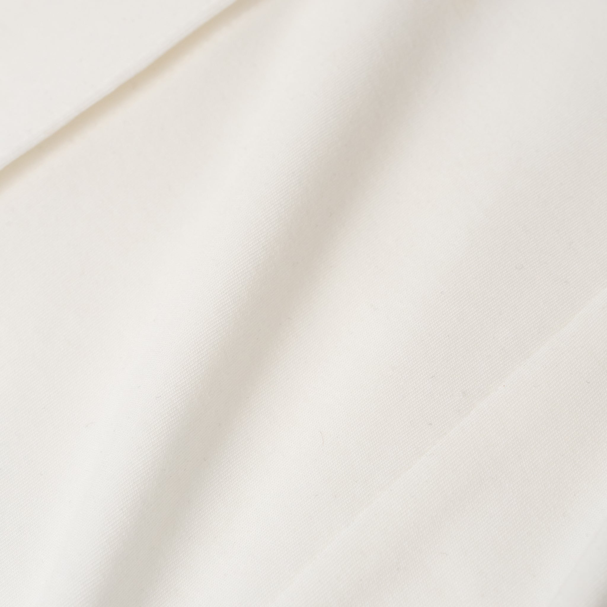 Close-up of white Ninepine Lenzing jersey fabric texture.